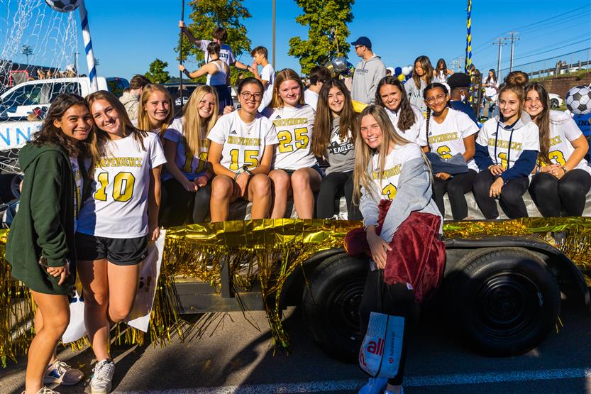 Students ride on a homecoming parade float